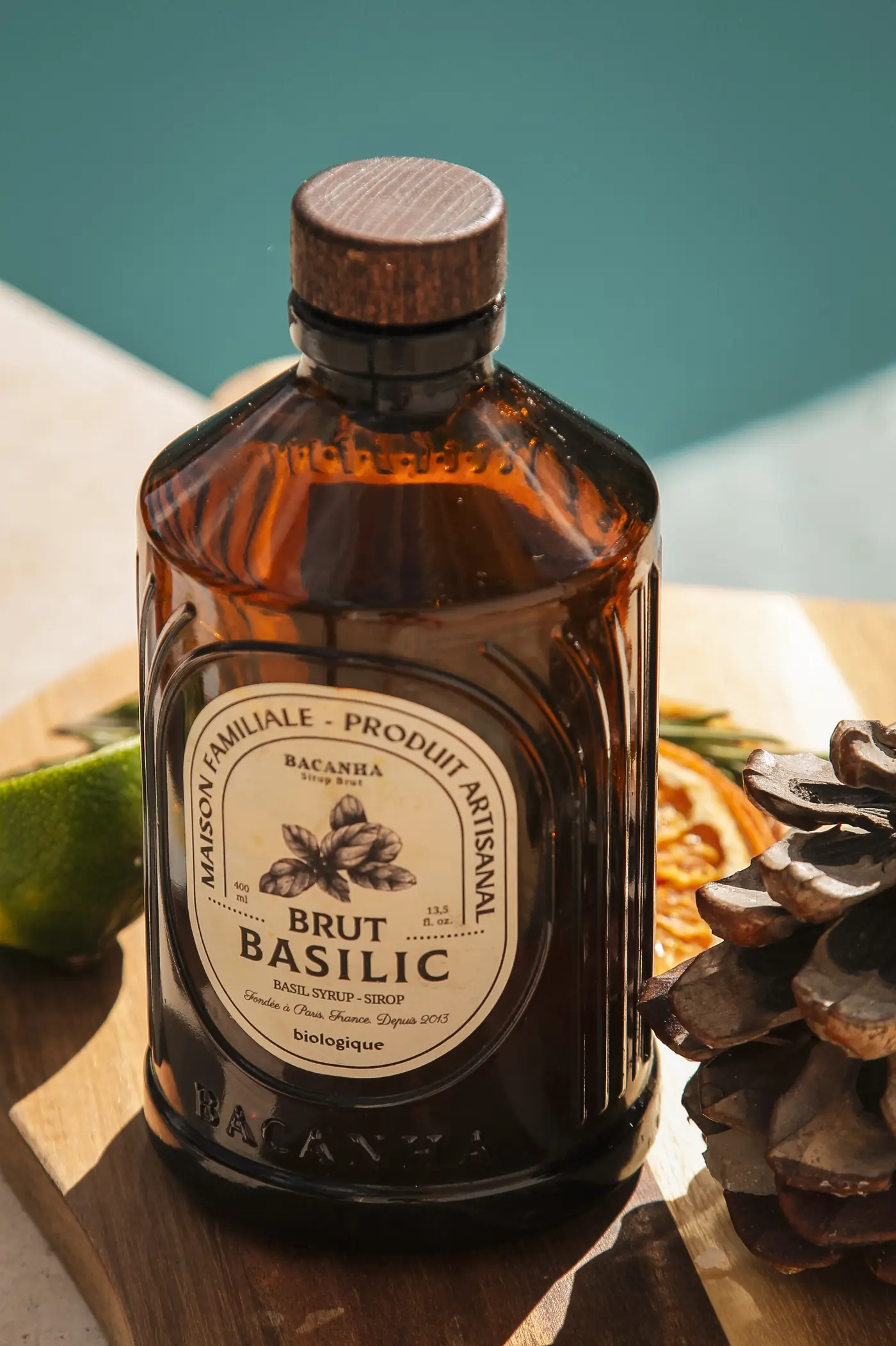 Sirop artisanal Brut Basilic posé au bord d'une piscine