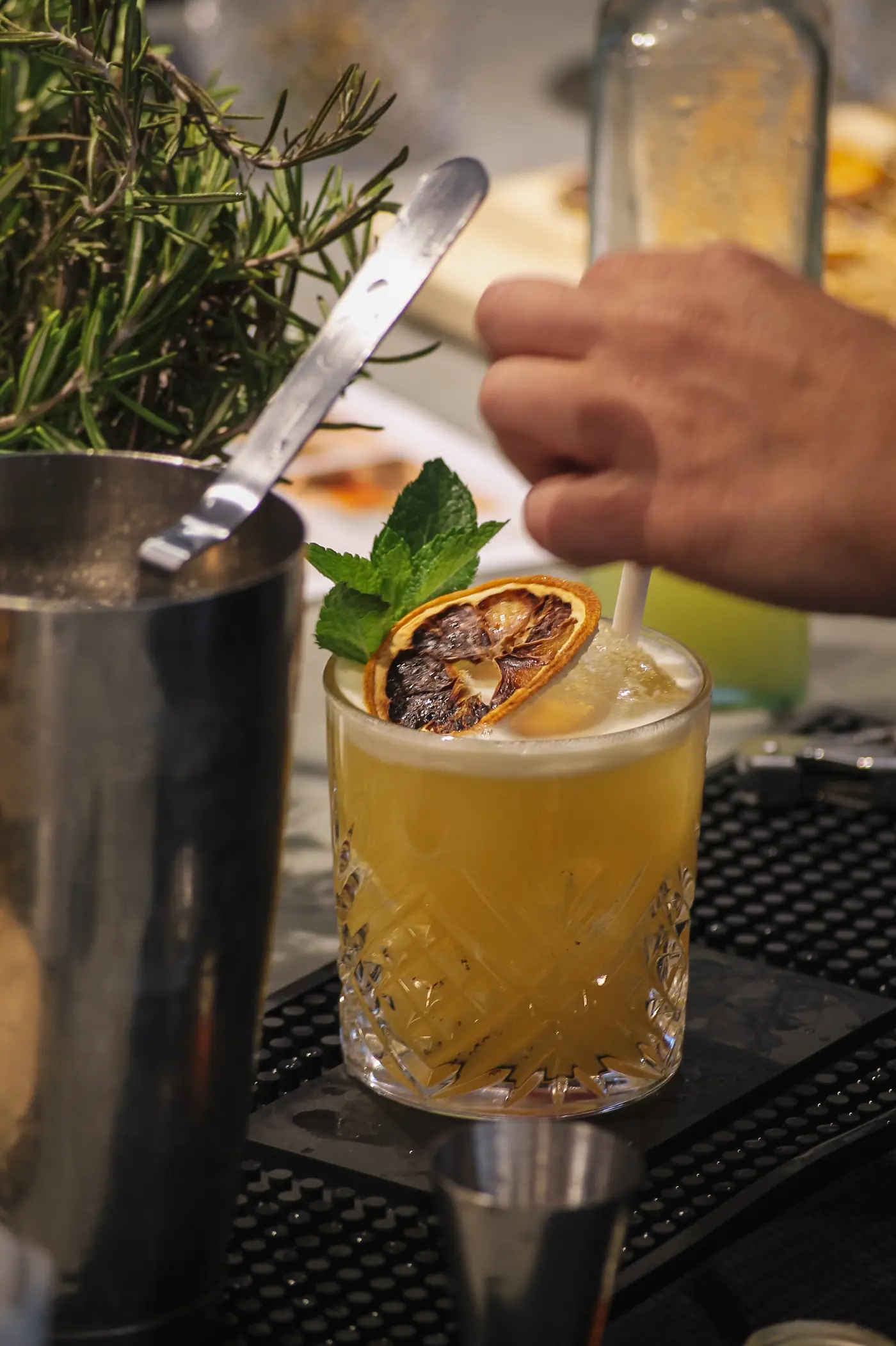Cocktail garni de menthe et d'orange séchée, préparation au shaker