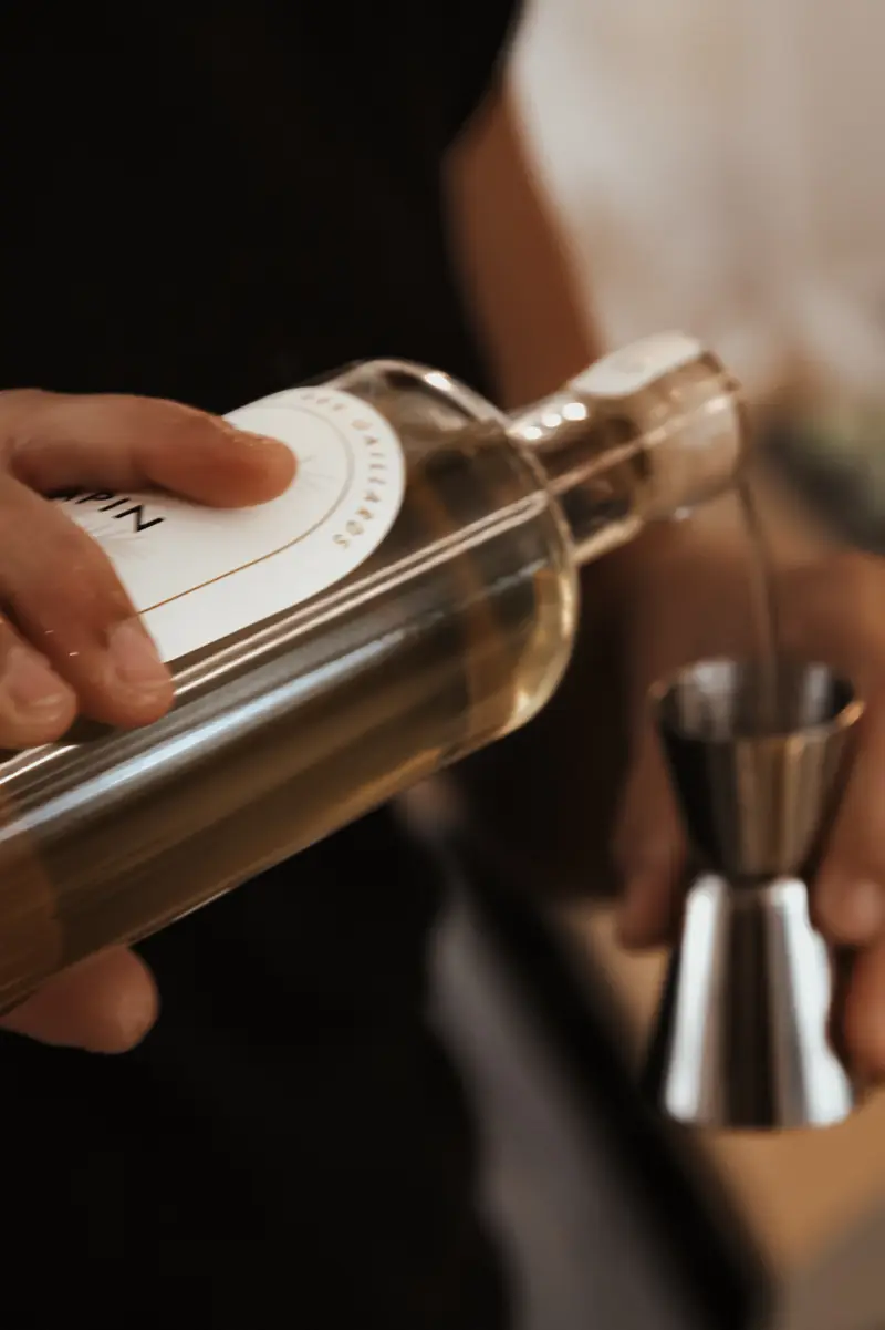 Dosage du gin au jigger derrière le bar