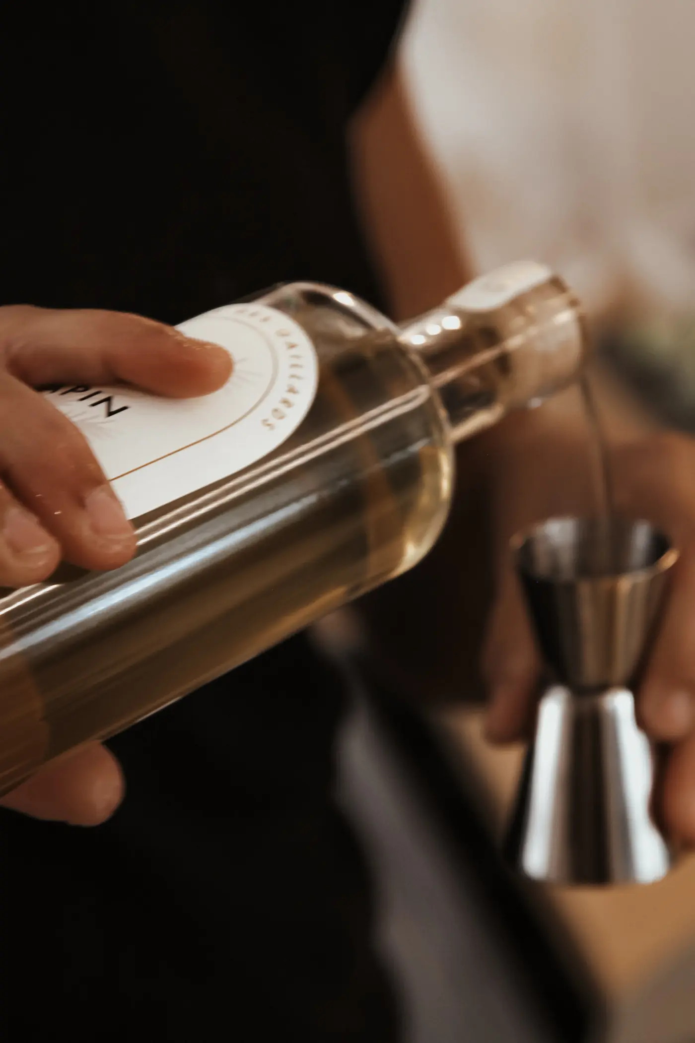 Dosage du gin au jigger derrière le bar